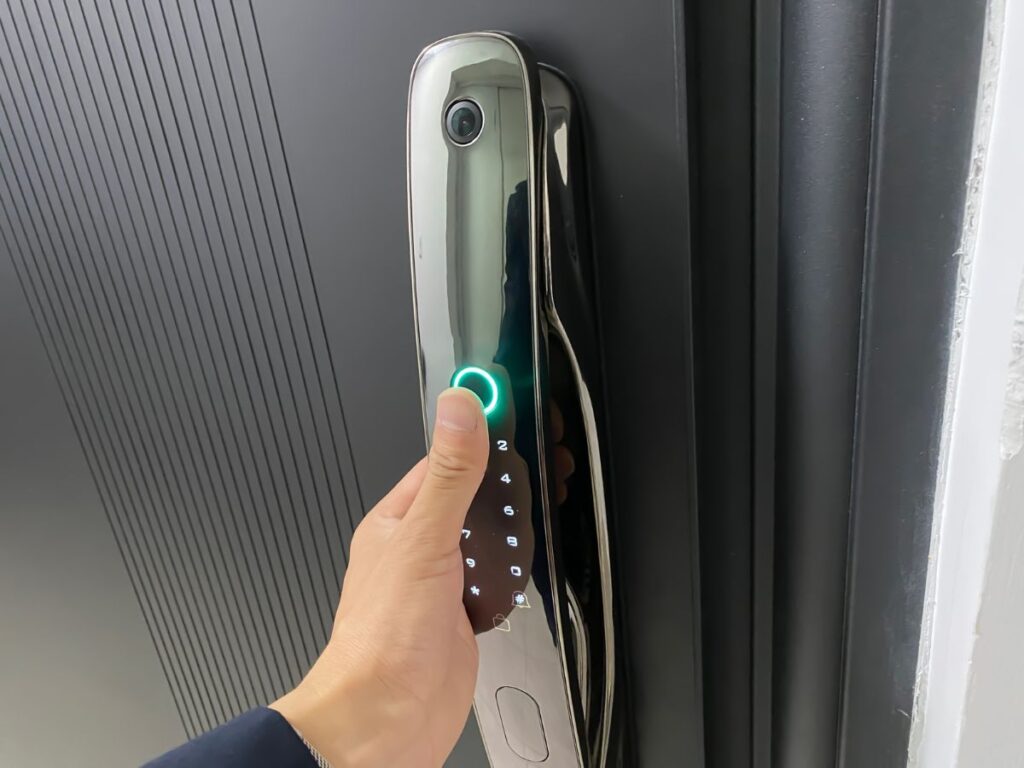 Fingerprint smart lock with glowing sensor on a dark front door