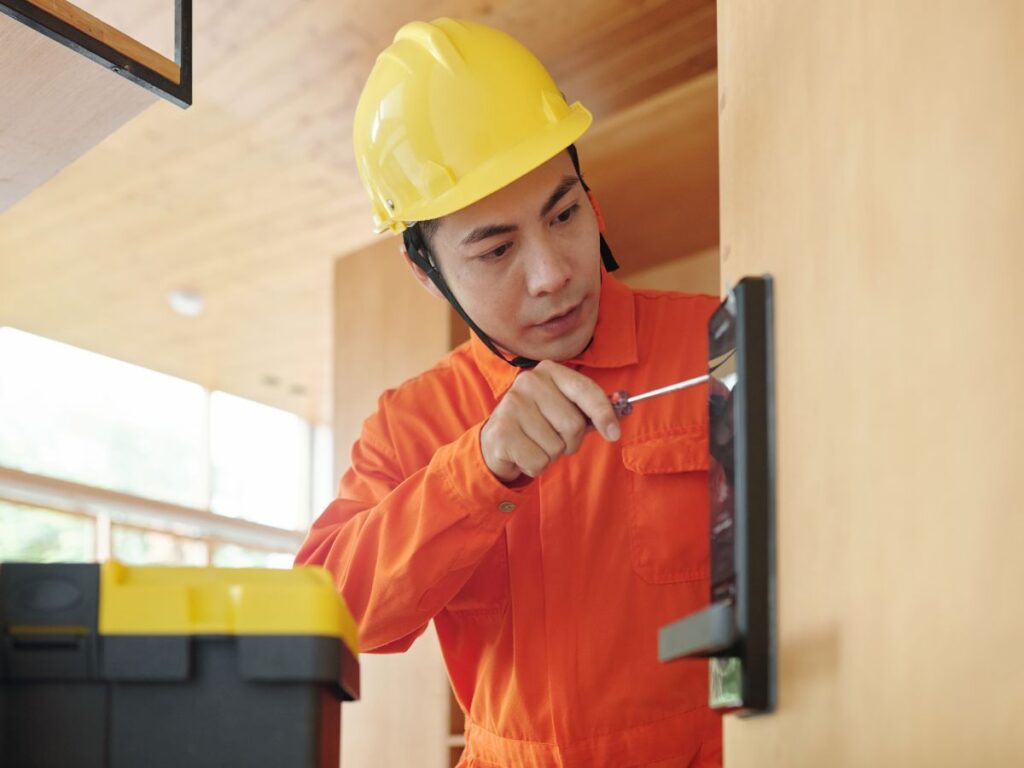Technician installing a smart lock on a wooden door