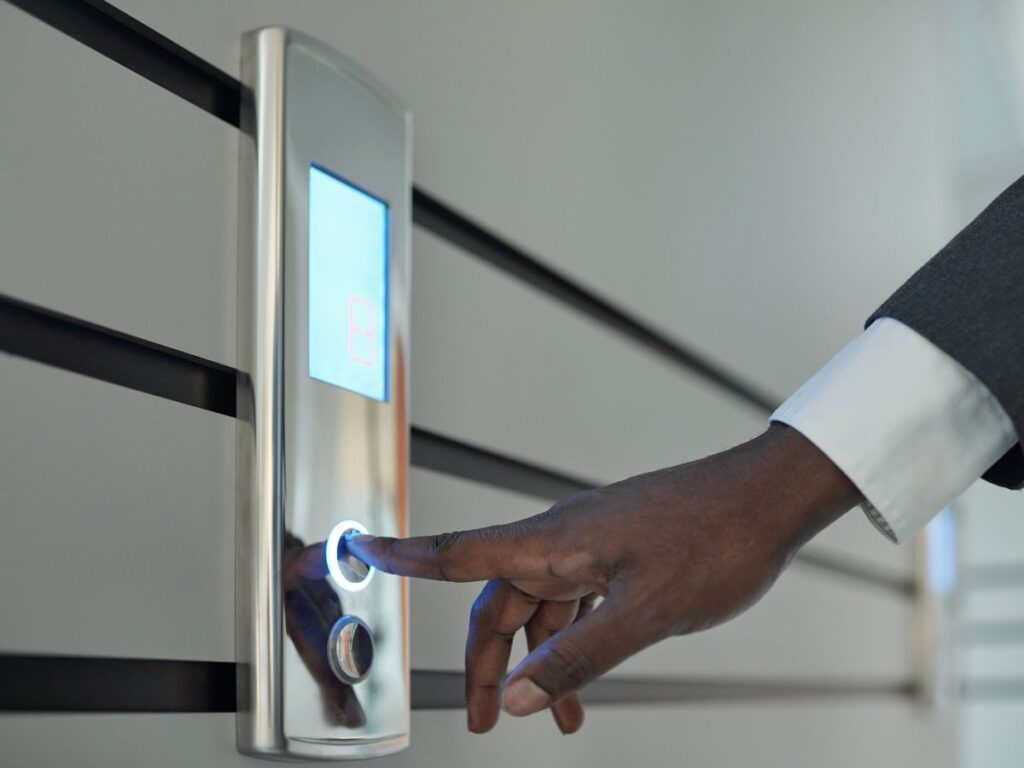Person using a modern digital access panel with illuminated touch control