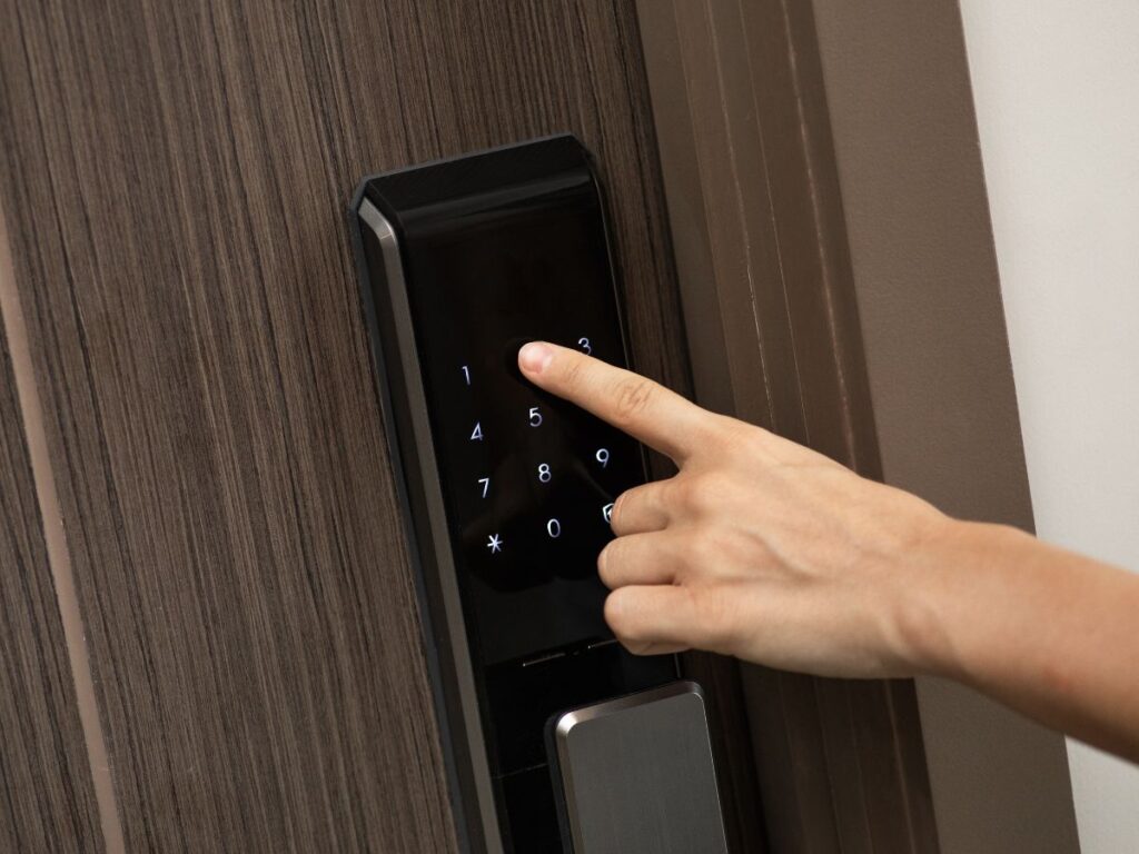 Hand enters a code on a touchscreen smart lock keypad
