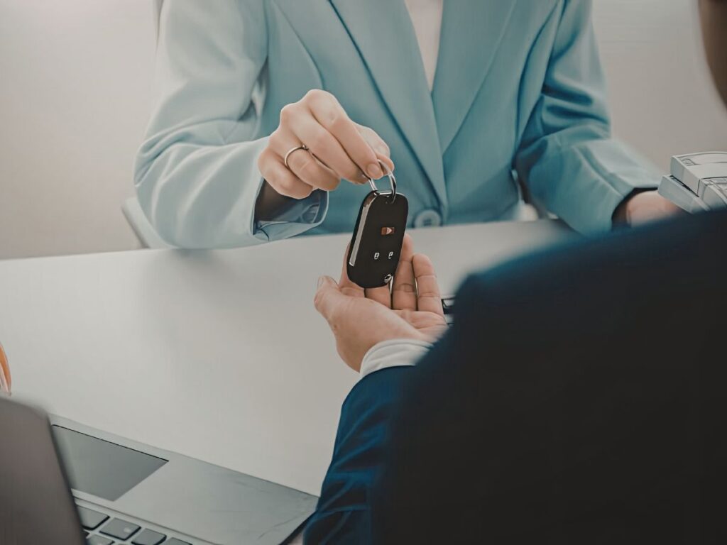 Customer receiving a car key fob from a dealership representative