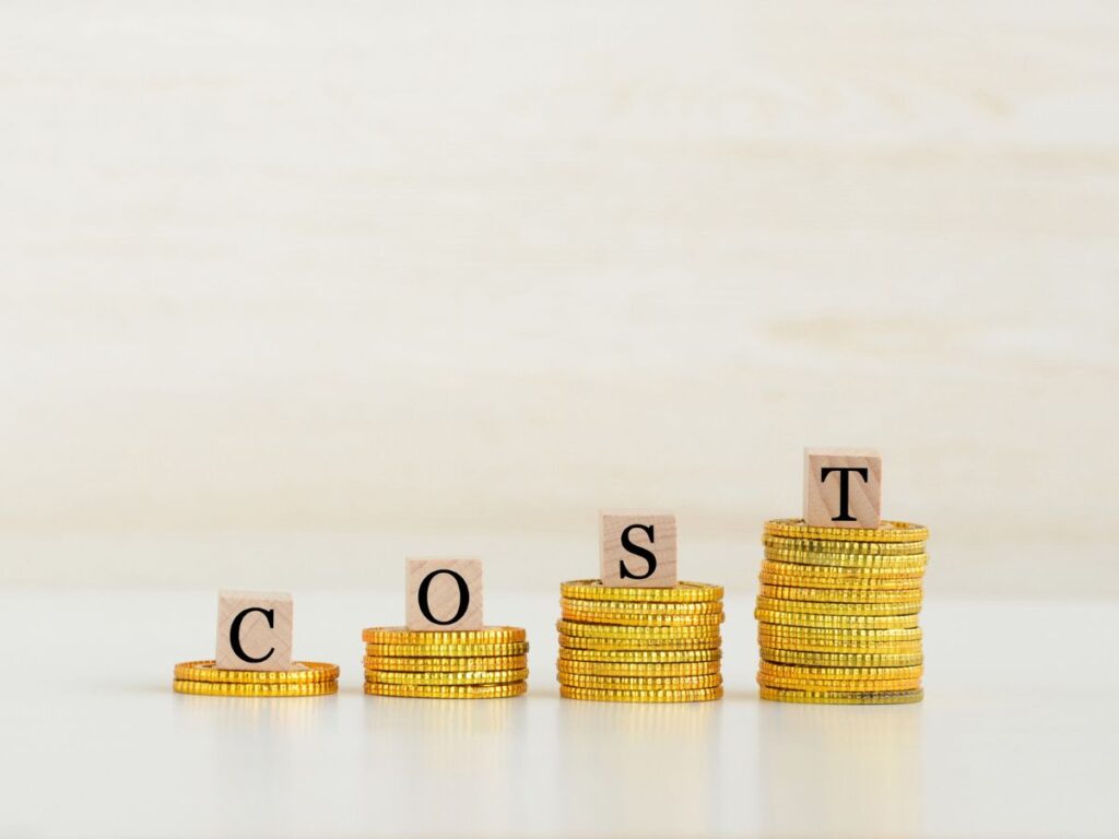 Stacks of coins spelling COST in rising columns